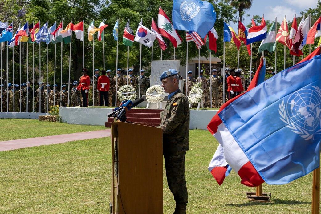 A representative at a podium addresses a crowd.